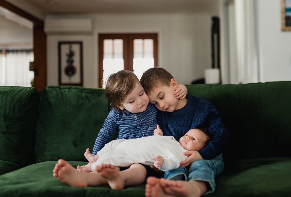 Two young kids holding new Babylon a couch.