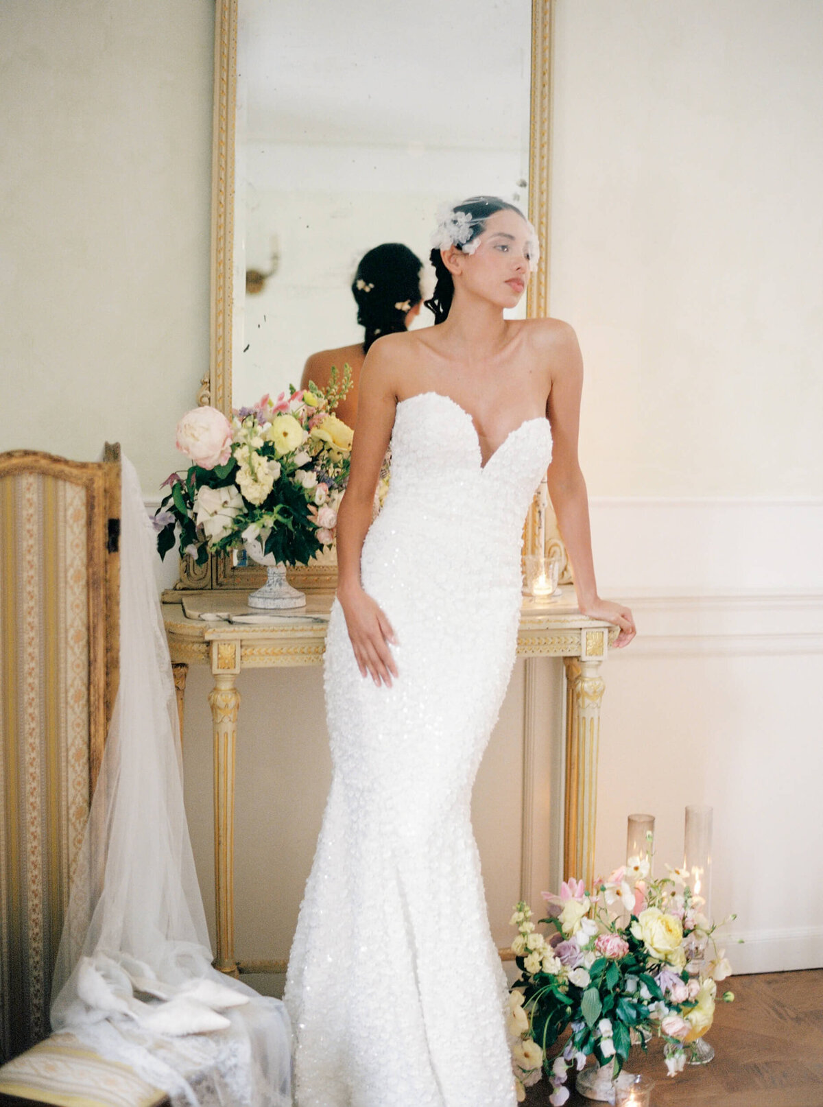 Bridal picture of a bride in a flowing white dress with florals surrounding her taken at villa aura del lago