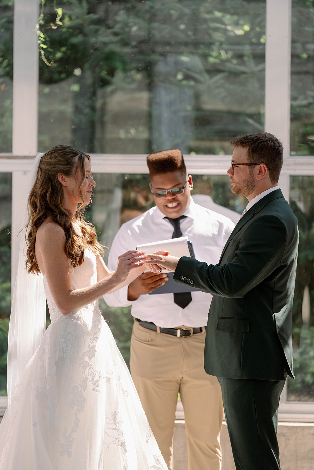 Close-up of the bride and groom sharing emotional vows inside the greenhouse at The Ivy House wedding venue in Saugatuck MI.