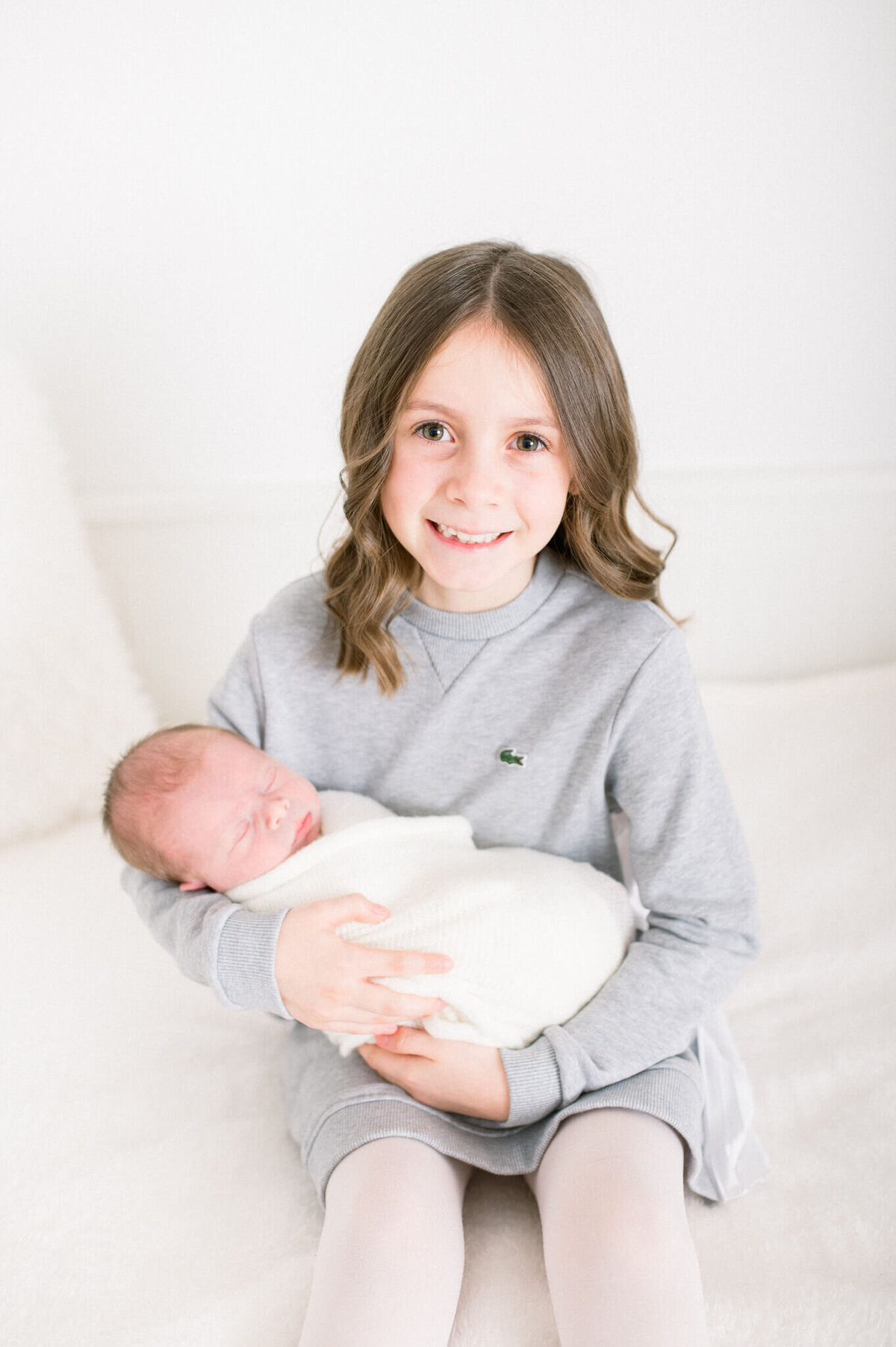 Niagara newborn photographer captures sister holding newborn brother