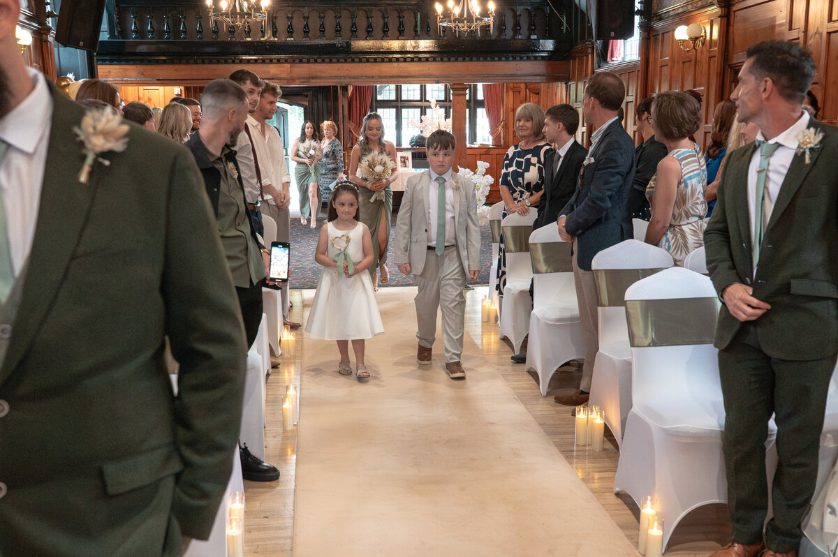 Flower girl and paige boys walking down the aisle at worsley court house 