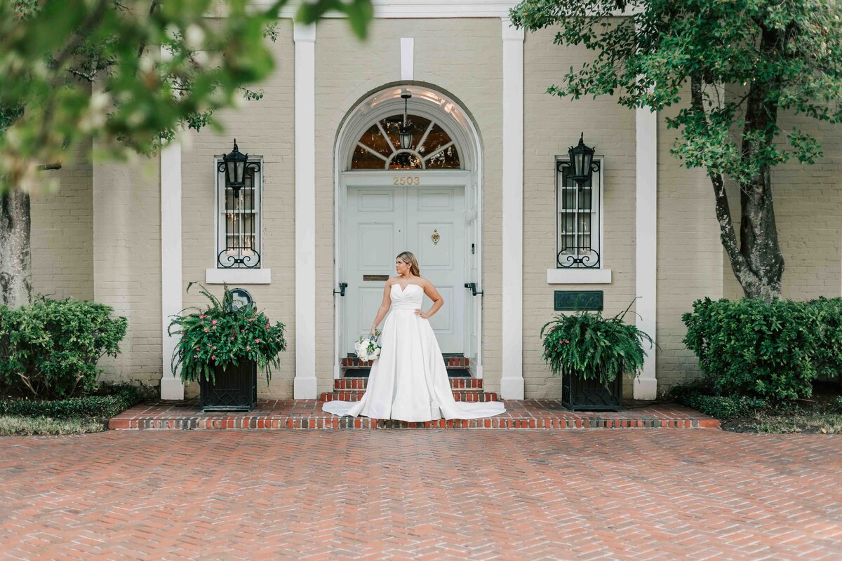 bride stands in front of rose garden at river oaks garden club for her bridal portraits
