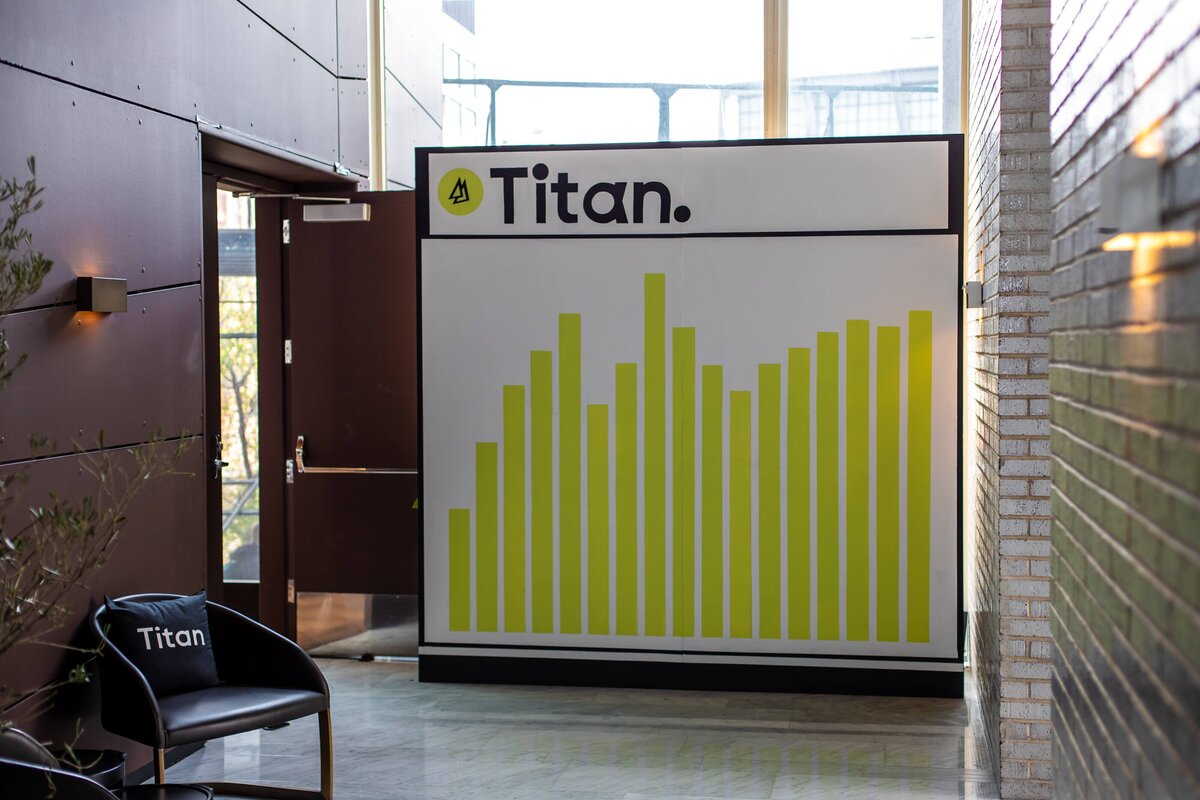 Titan-branded wall display with bold chart design.