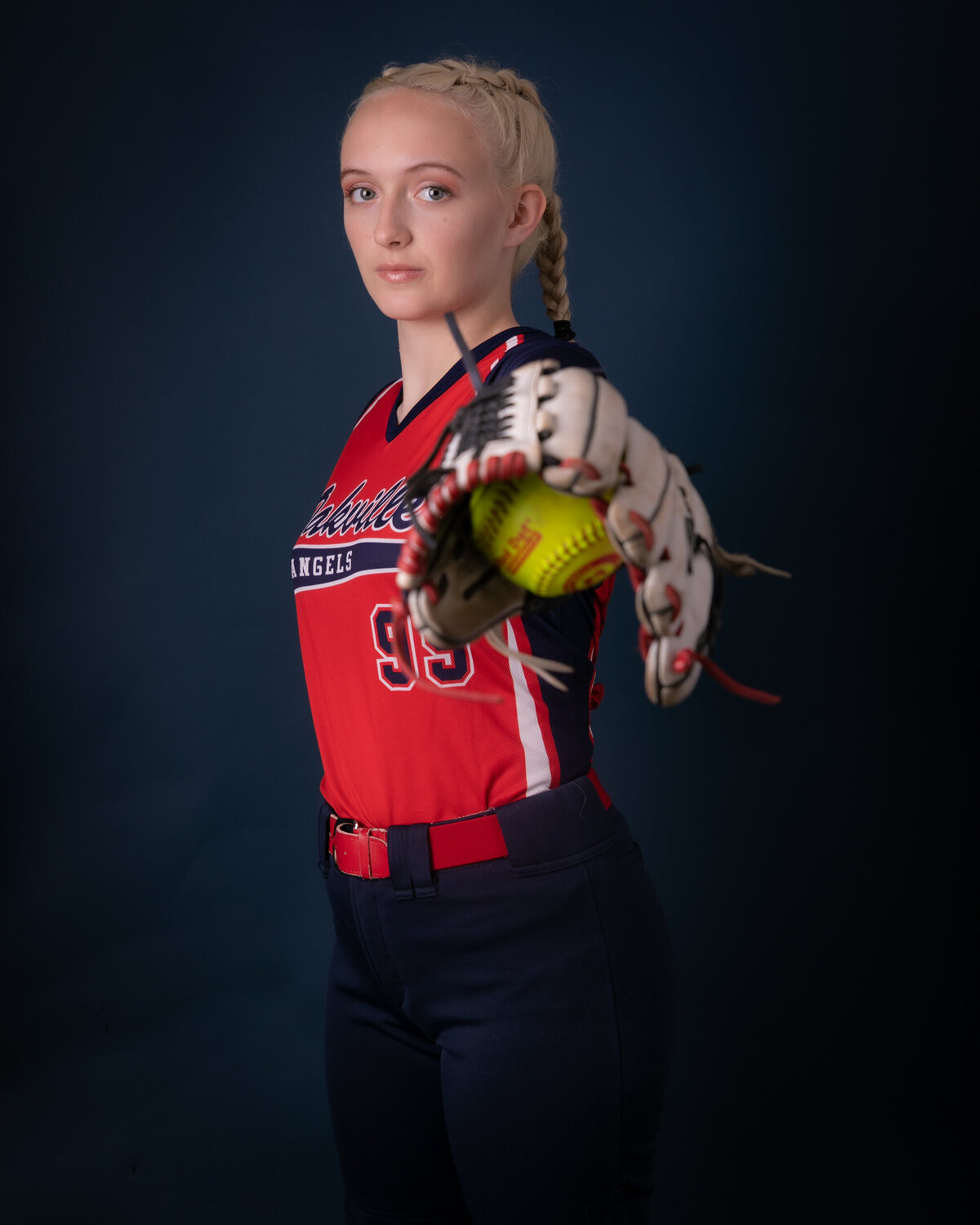 Baseball player holding her mit and glove. 