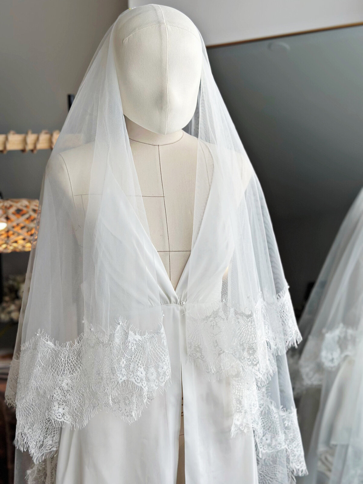 Bride’s blusher veil with floral lace framing her face
