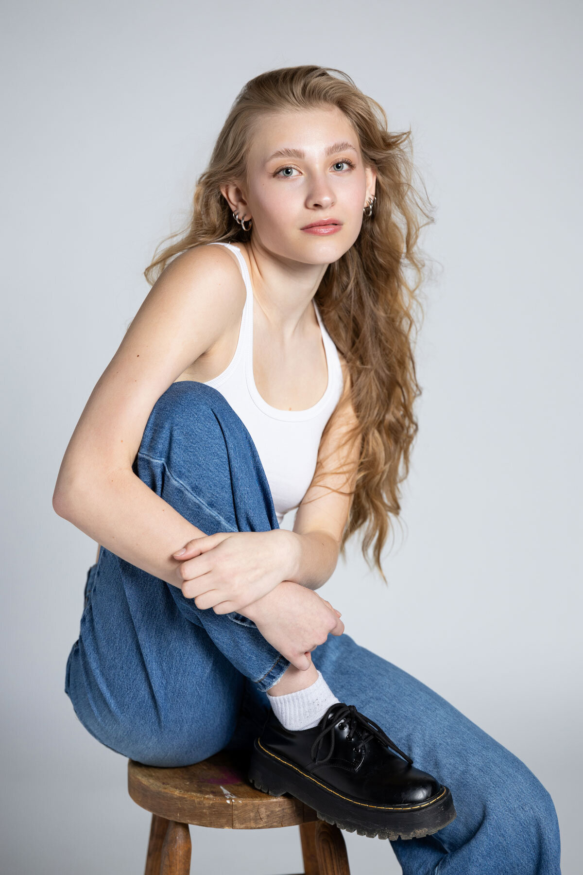 Senior pictures of girl sitting on stool with Doc Marten shoes in Salt Lake City Utah.