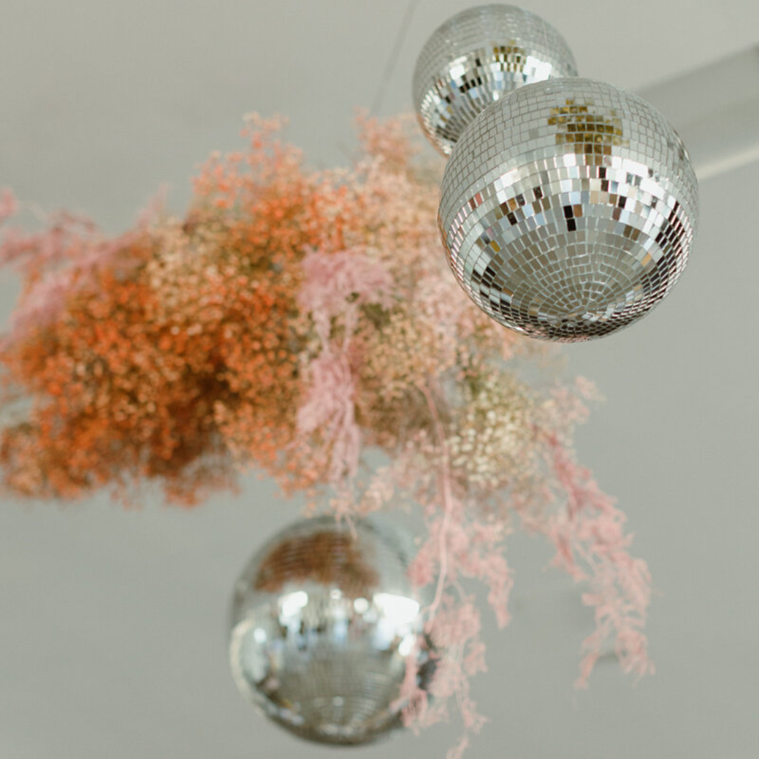 Hanging disco balls with pink baby’s breath installation, part of a custom Austin event floral design for weddings or branded corporate celebrations.