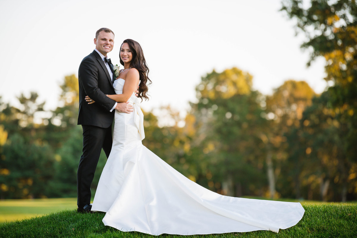 bride and groom hugging on the golf course at The Muttontown Club