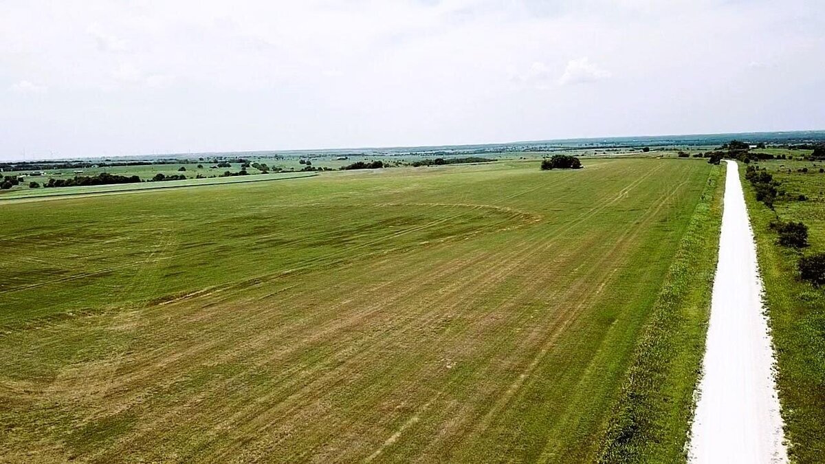 Aerial view of 11-acre property in Lindsay, Texas with open fields and clear skies
