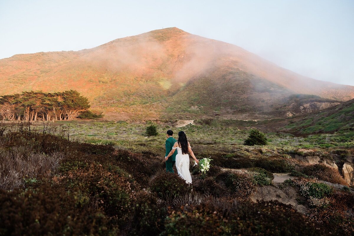 The fog roll in while the bride and groom walk along the trail at Garrapata State Park.