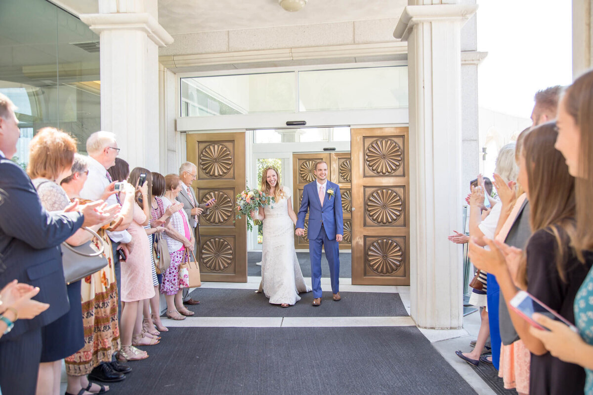 bride and groom exit the draper lds temple happily after wedding ceremony