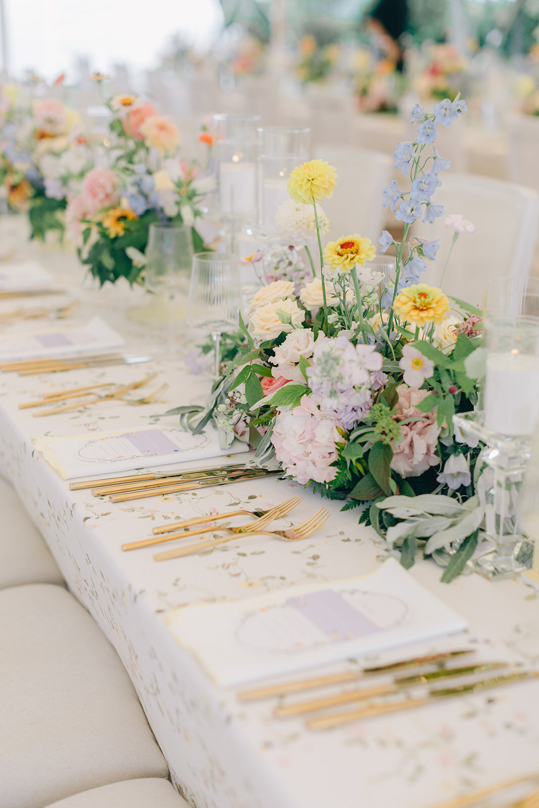 Lush, pastel flowers in long centrepieces at a Forest and Stream Club wedding reception.