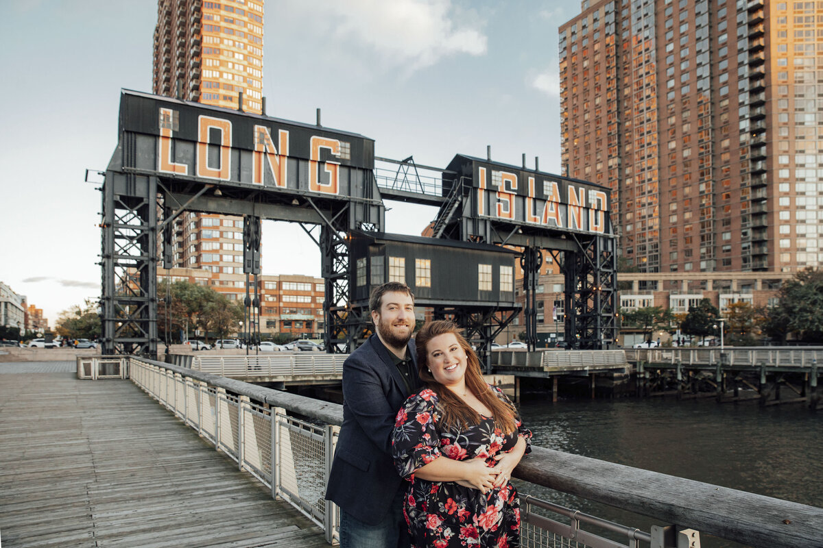 Couple by Queens sign during engagement photo on Long Island New York