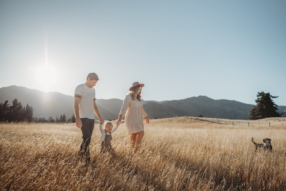 a fmaily walking in the field in wanaka at sunet for a family photrgraphy session  captured by Bie