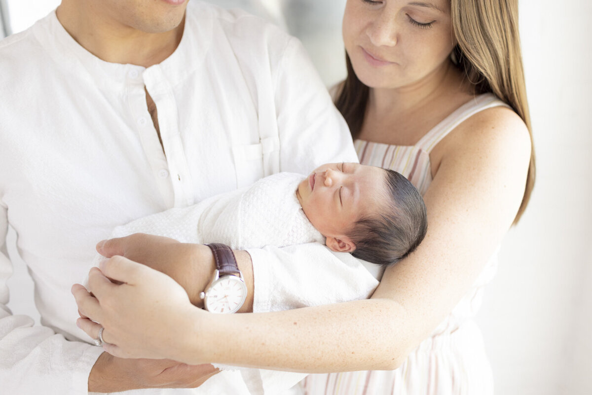 parents holding newborn baby boy