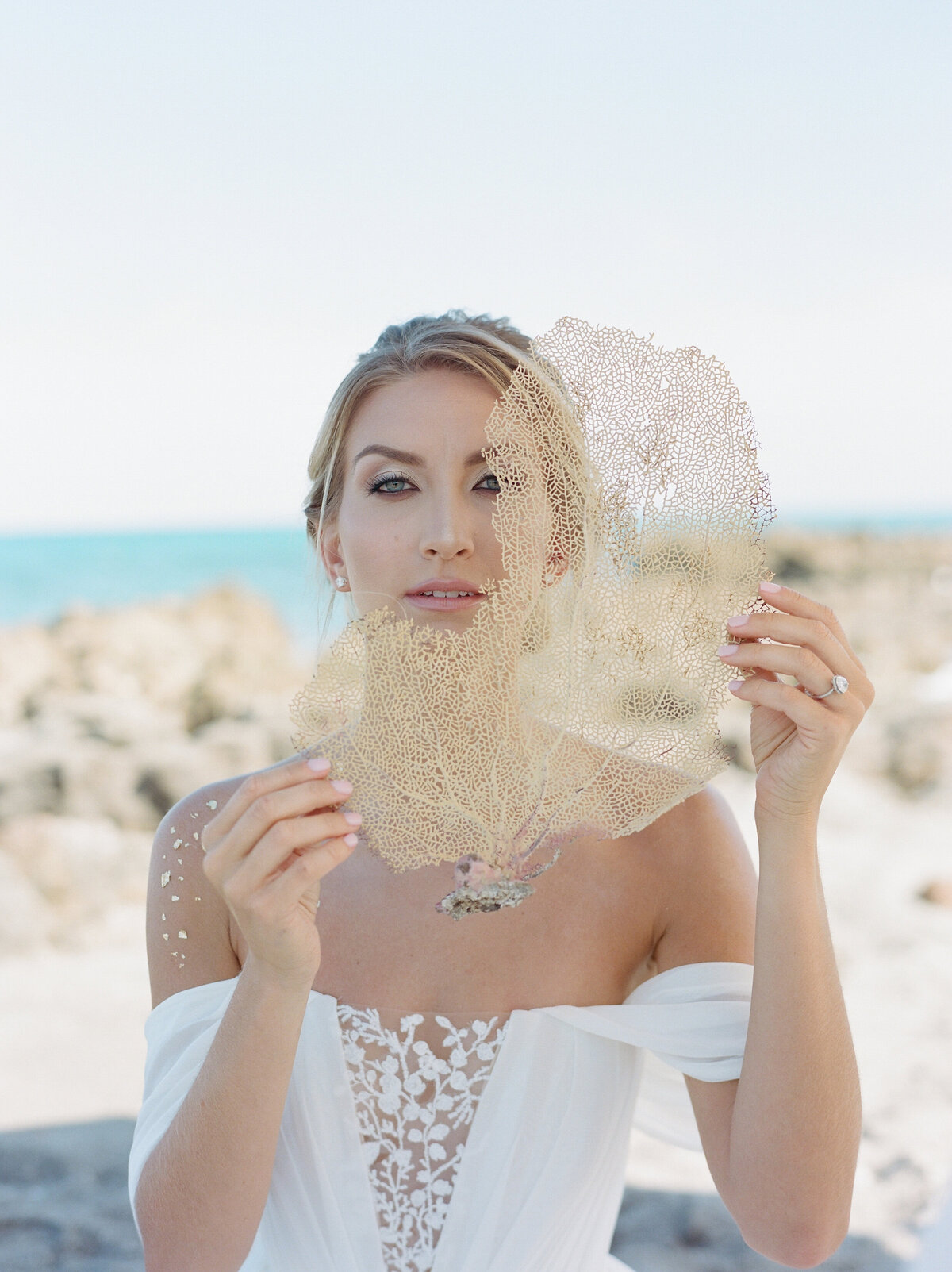 Bride holds something in front of her face.