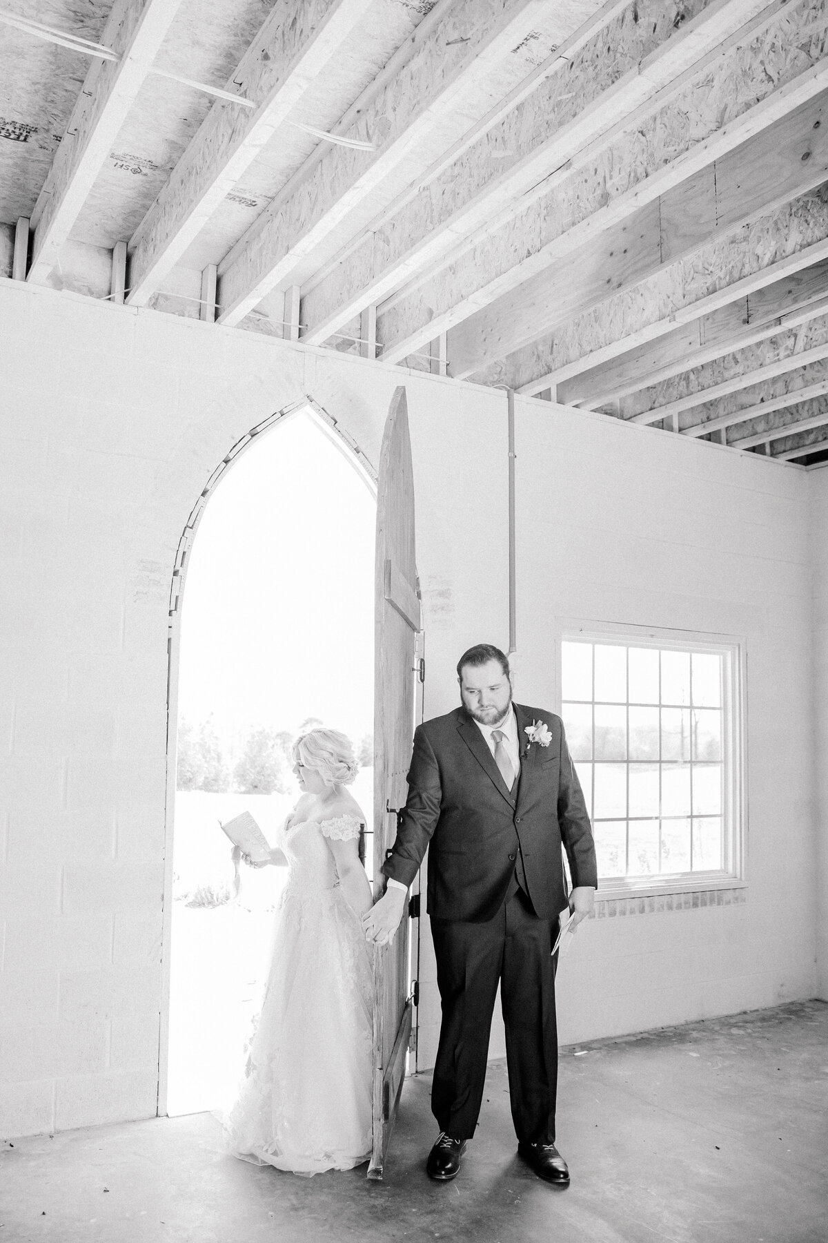 Bride and Groom holding hands around a door during their first touch