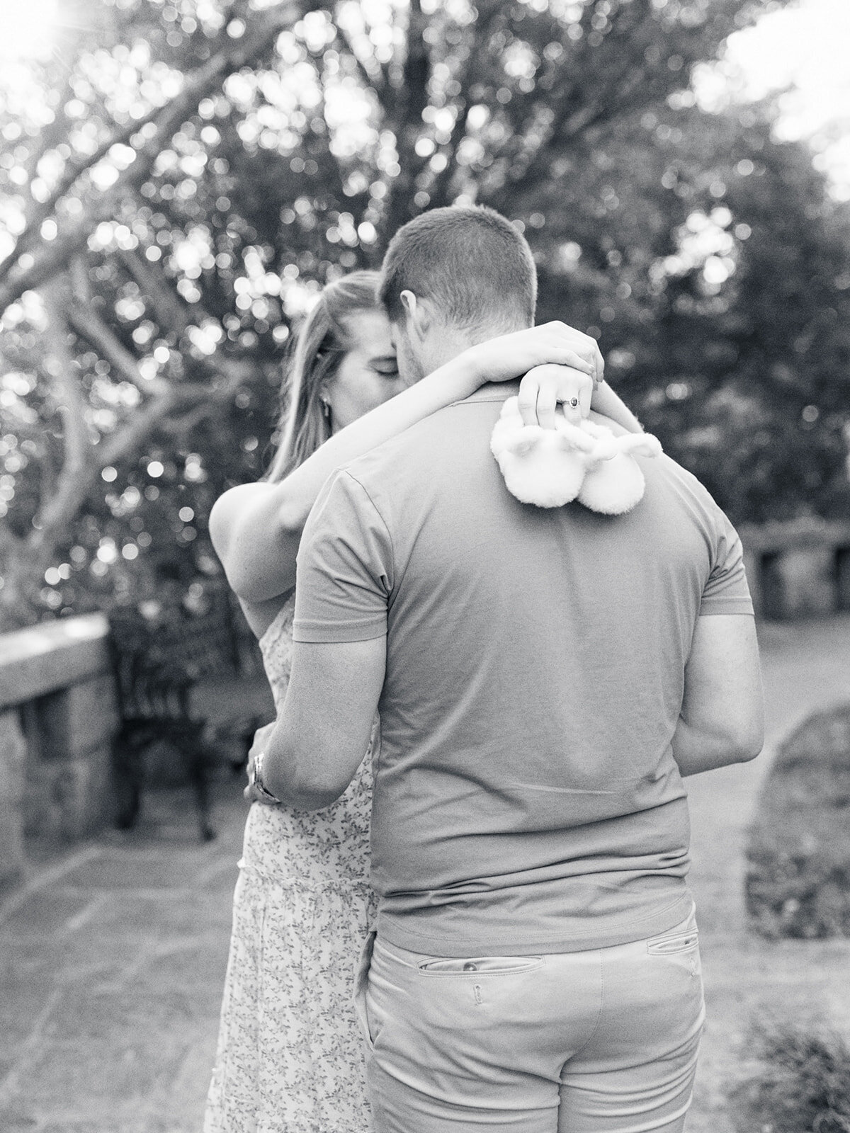 A couple touching foreheads while the mother holds baby slippers during a Richmond maternity photography session by Katie Stansfield Photography.