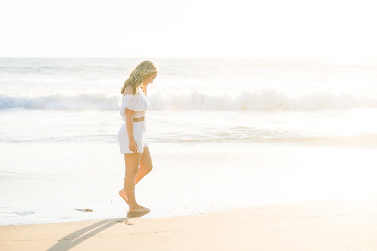 Maui senior portrait of girl walking on the beach with waves crashing in the background
