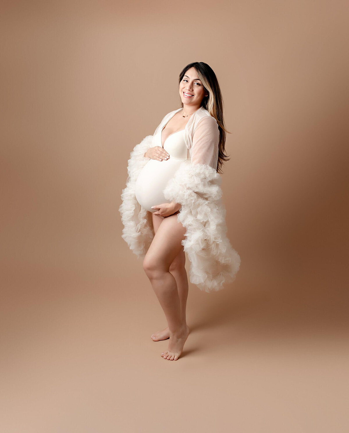 A stunning mom-to-be embracing her pregnancy in a chic Brooklyn studio session
