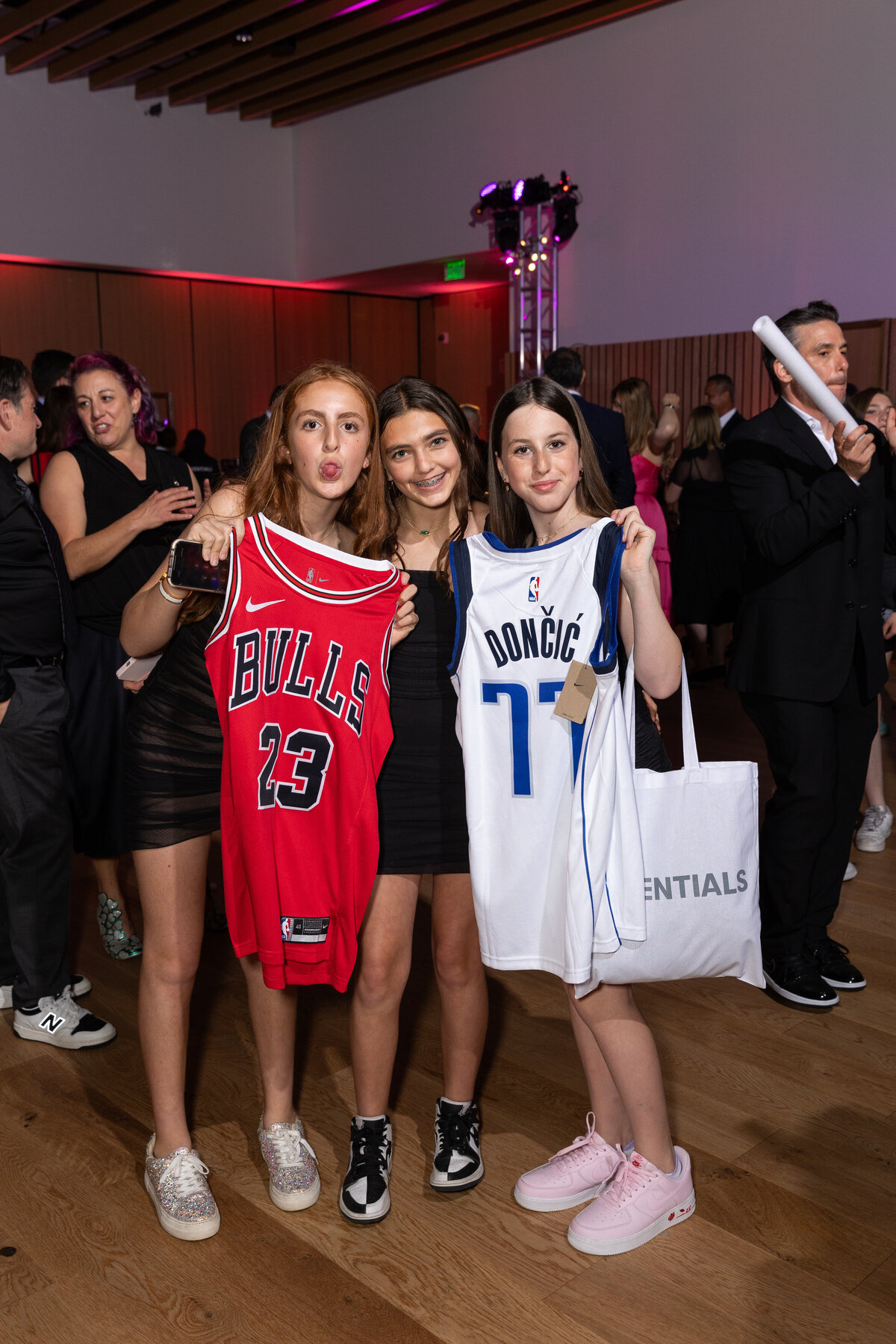 Girls holding up NBA jerseys