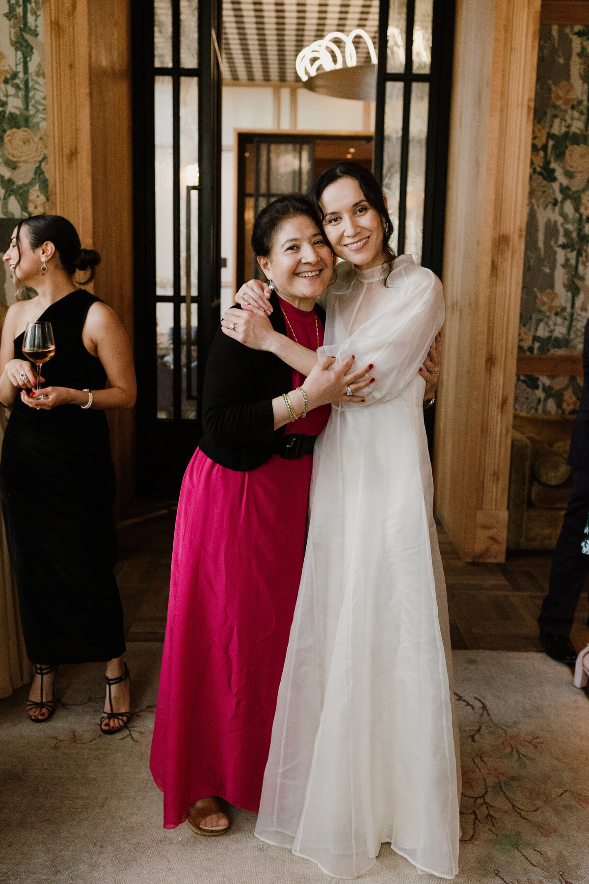 Bride hugging mother at intimate wedding reception at Poper hotel, Austin