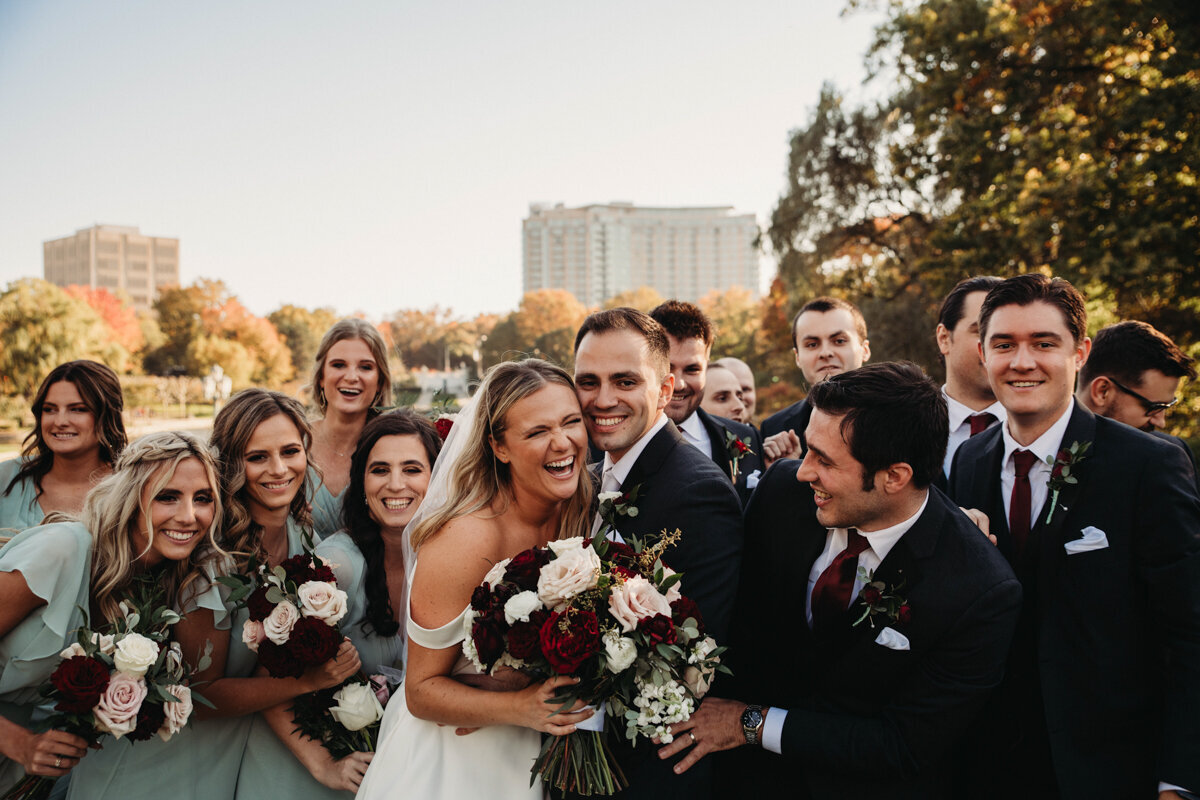 Large wedding party surround bride and groom at Cleveland Museum of Art
