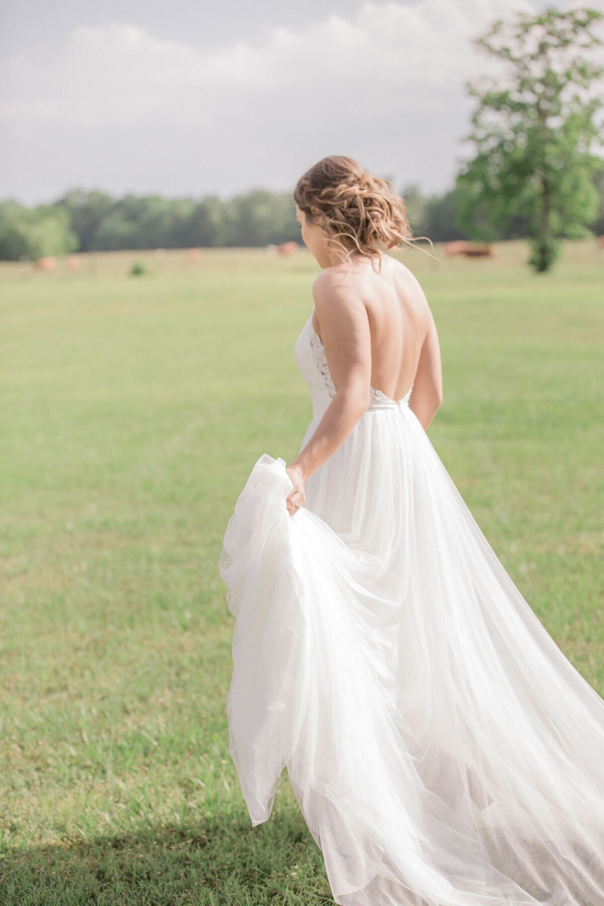The bride, walking away from the camera, shows off her tulle train