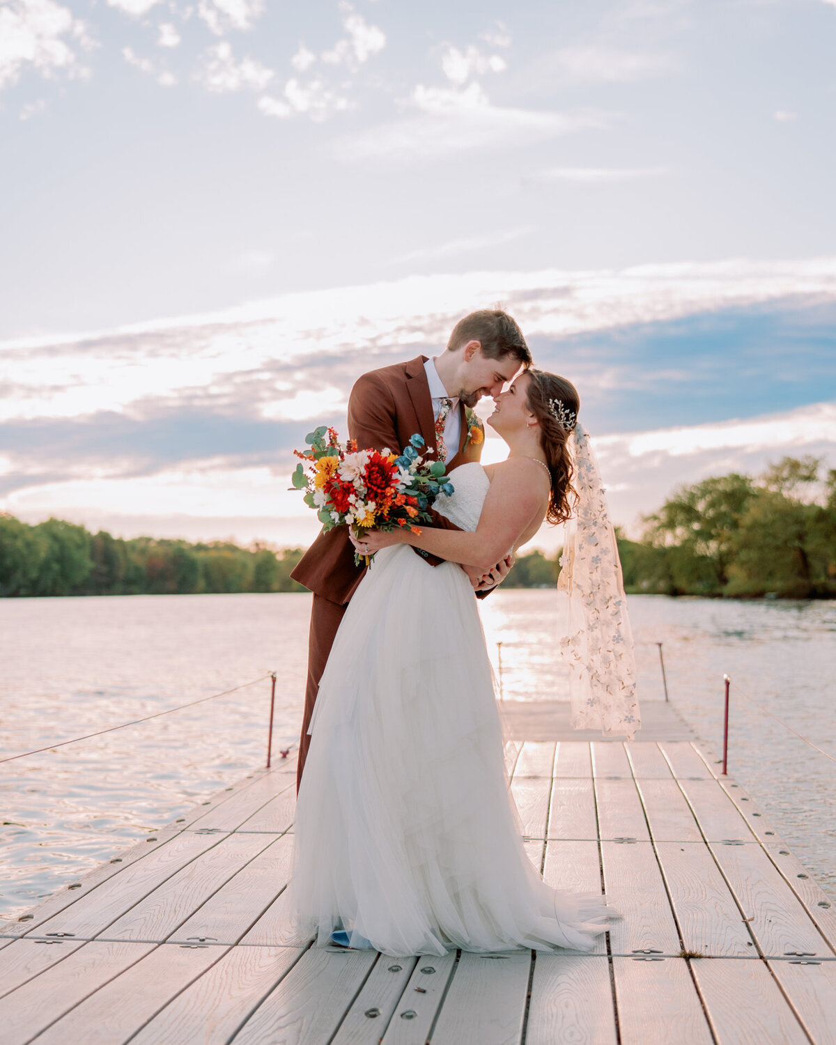 A newlywed dipping their partner slightly as they are forehead to forehead 