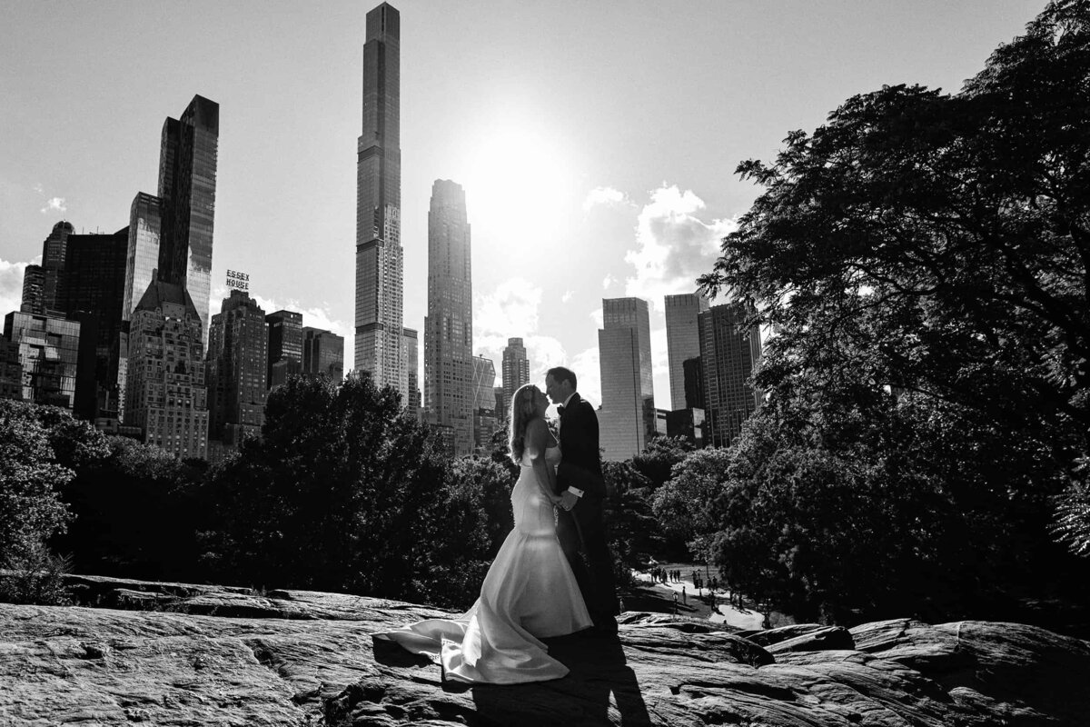 A couple kiss on Cat Rock after their wedding in Central Park, New York.
