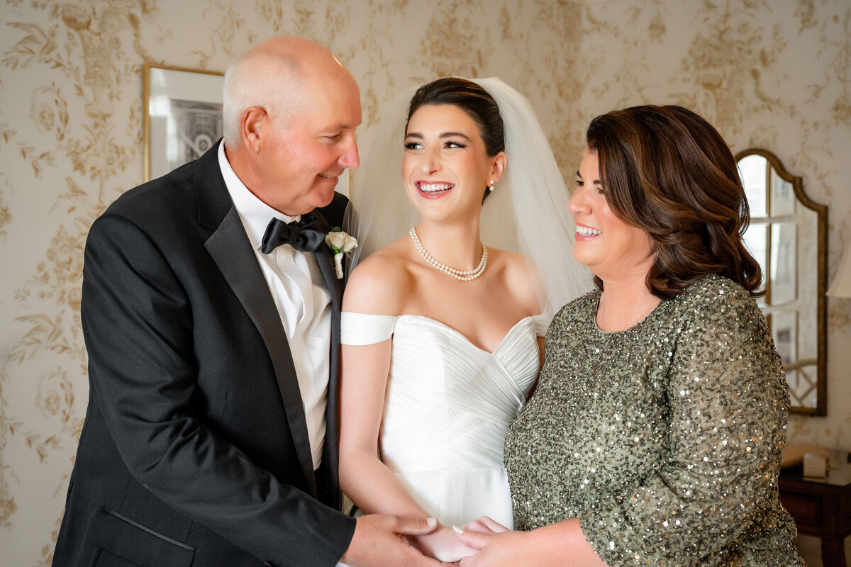 bride and her parents smiling on wedding day