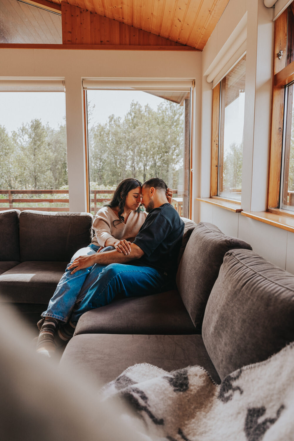 Husband and wife snuggle up on an Iceland sofa