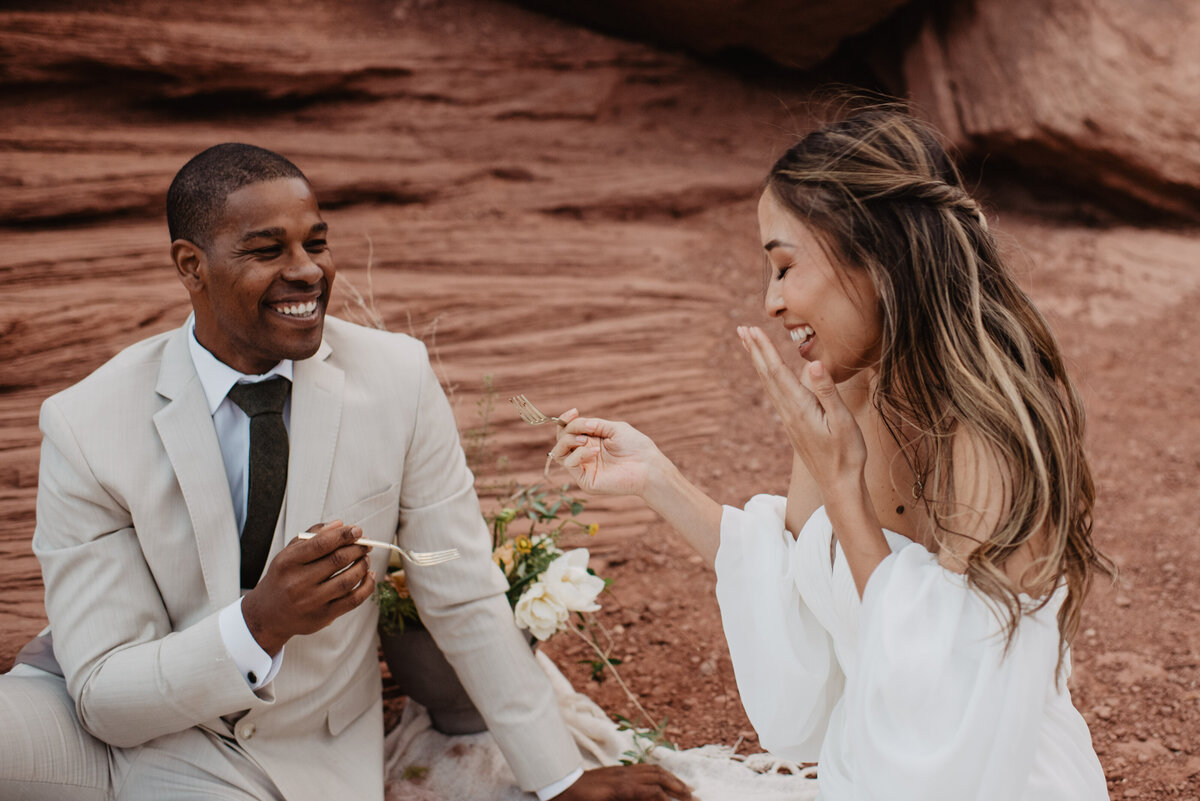 Utah Elopement Photographer captures couple eating wedding cake