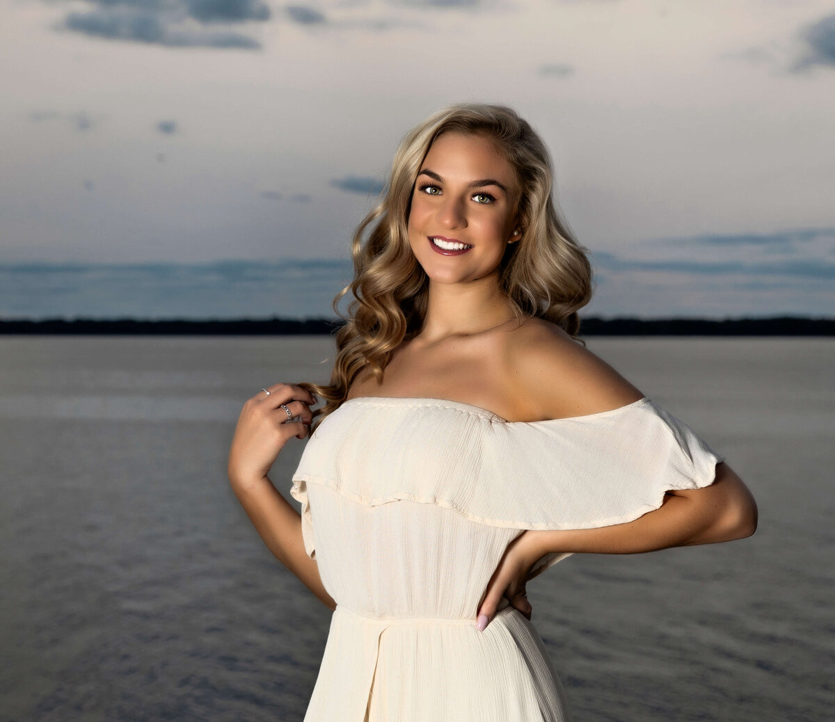 Senior photo of a girl in a white dress standing by the water on the Erie Pa bayfront