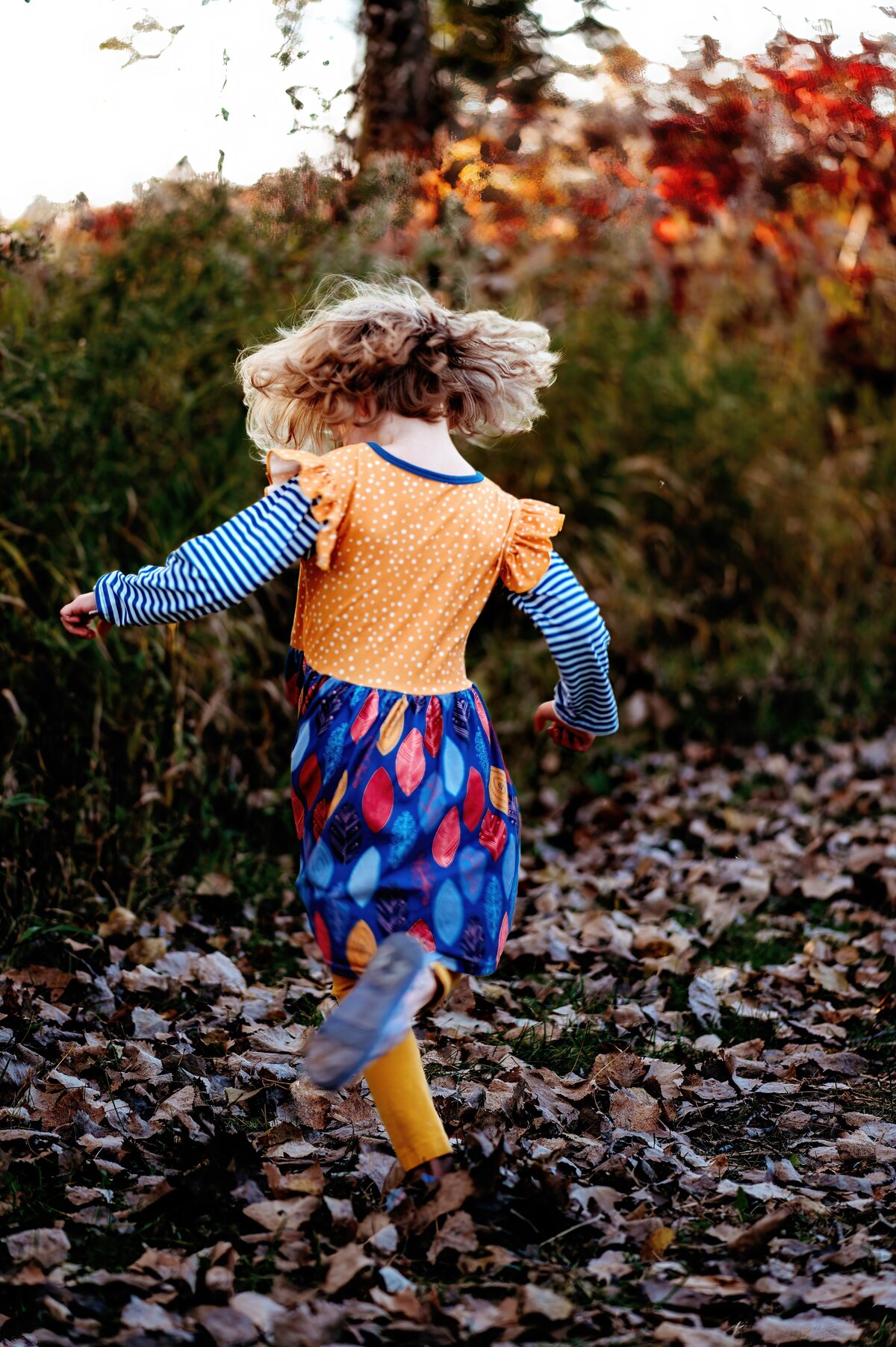 Child twirling in fall McKennaPattersonPhotography