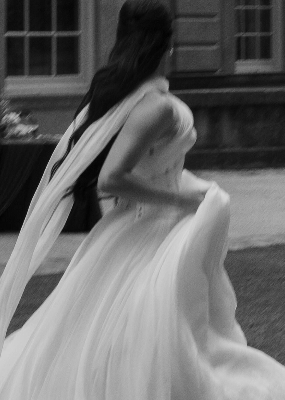 Black and white motion blur of a bride running in a flowing wedding dress, captured in an editorial documentary style by Kayt Zirkle Photography at the historic Swan House in Atlanta.