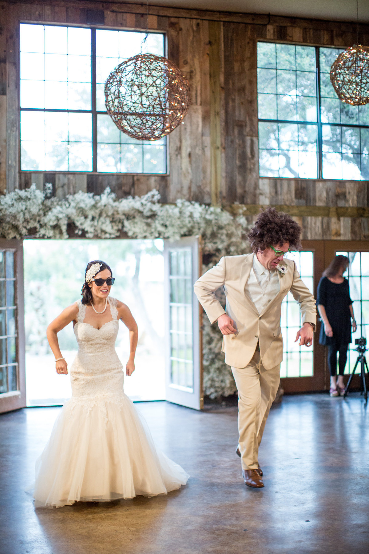 Bride and groom dressed silly for their grand entrance at Vista West Ranch. Groom is wearing a silly wig and Bride is wearing sunglasses.