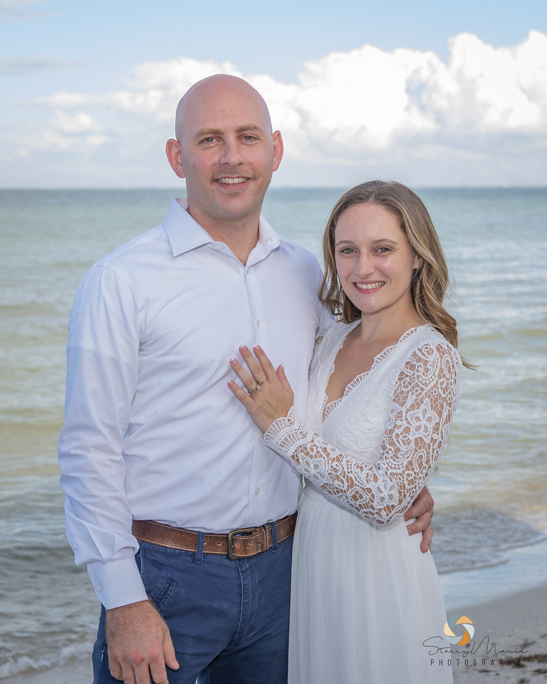 Newlyweds pose in front of the ocean for their wedding photos.