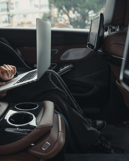 person sitting in car on laptop