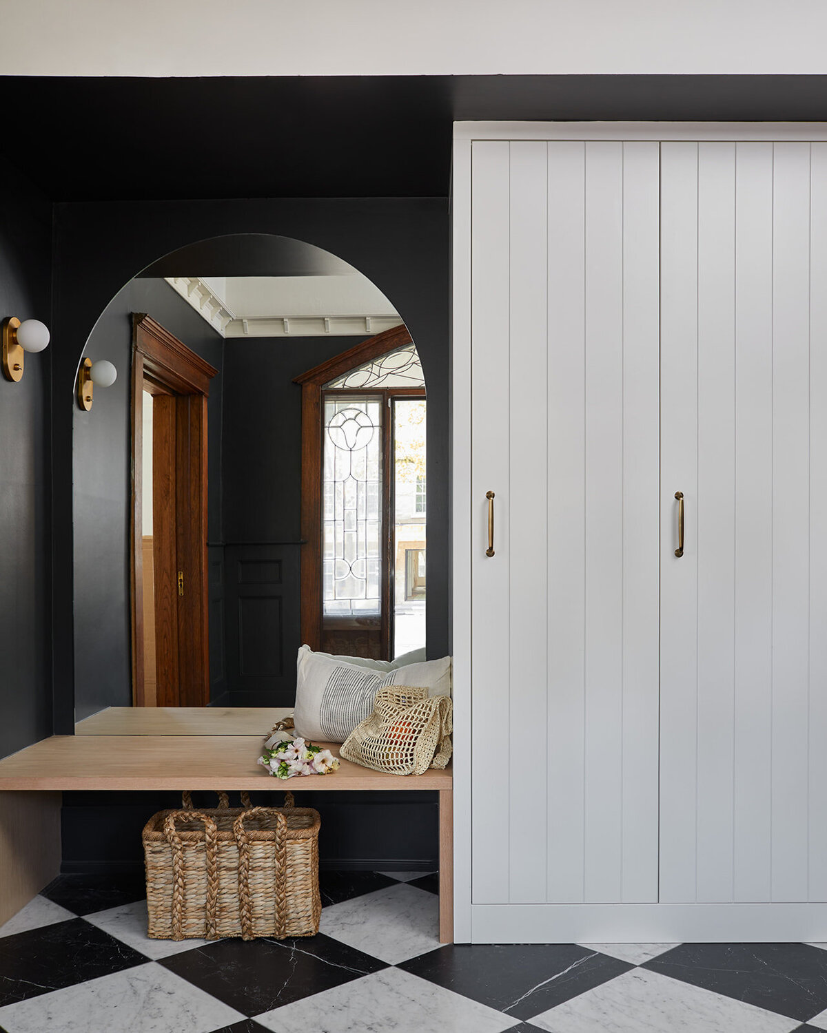 Laundry room with fun black and white tiles with a star pattern, soft blue cabinets, a farmhouse style sink, and a black washer and dryer