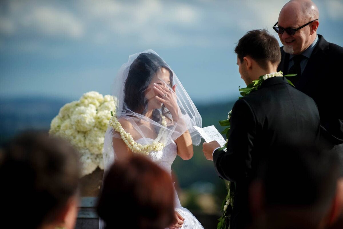 a bride wipes away a tear during wedding vows