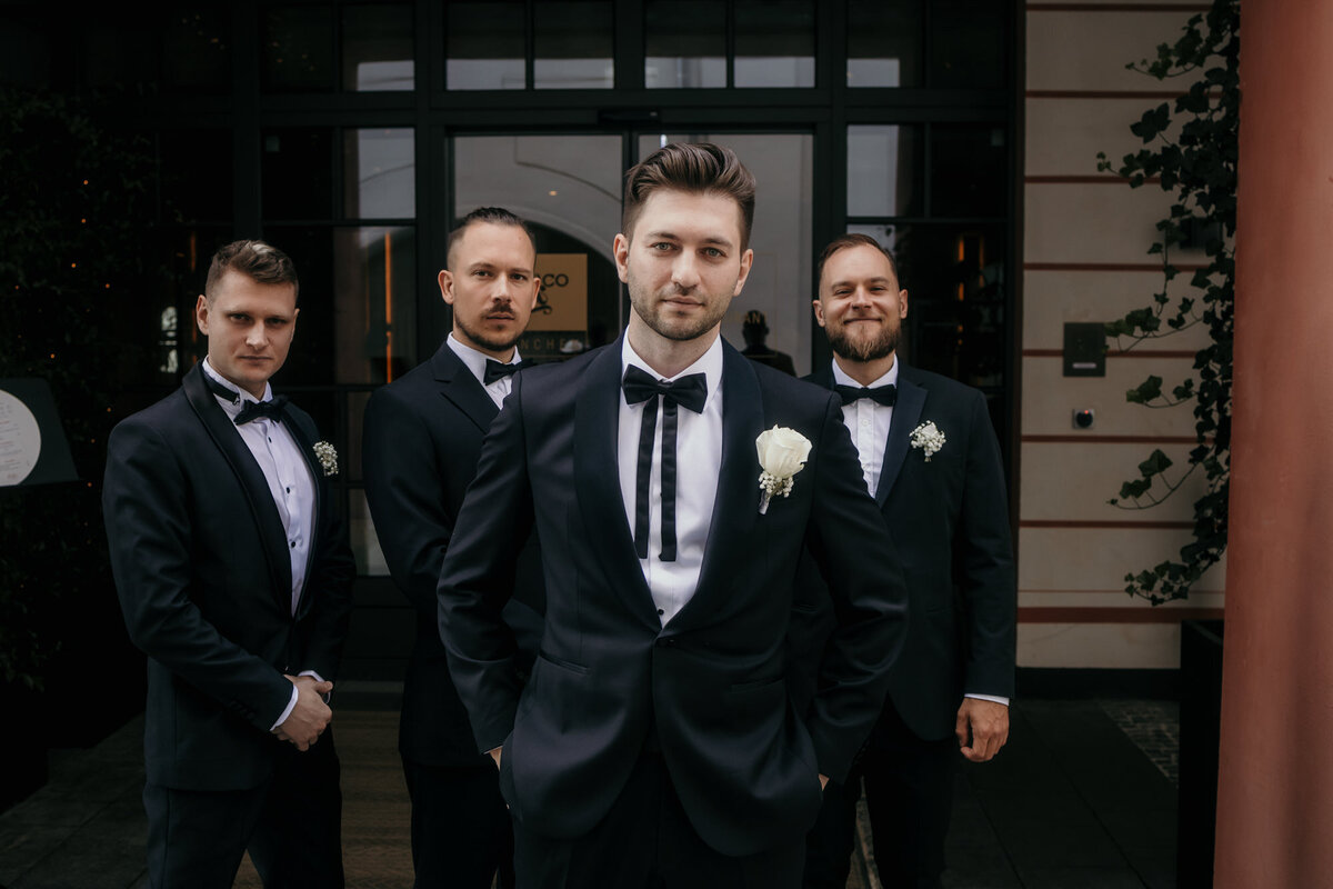 Groom poses with his boys in front of the wedding venue.