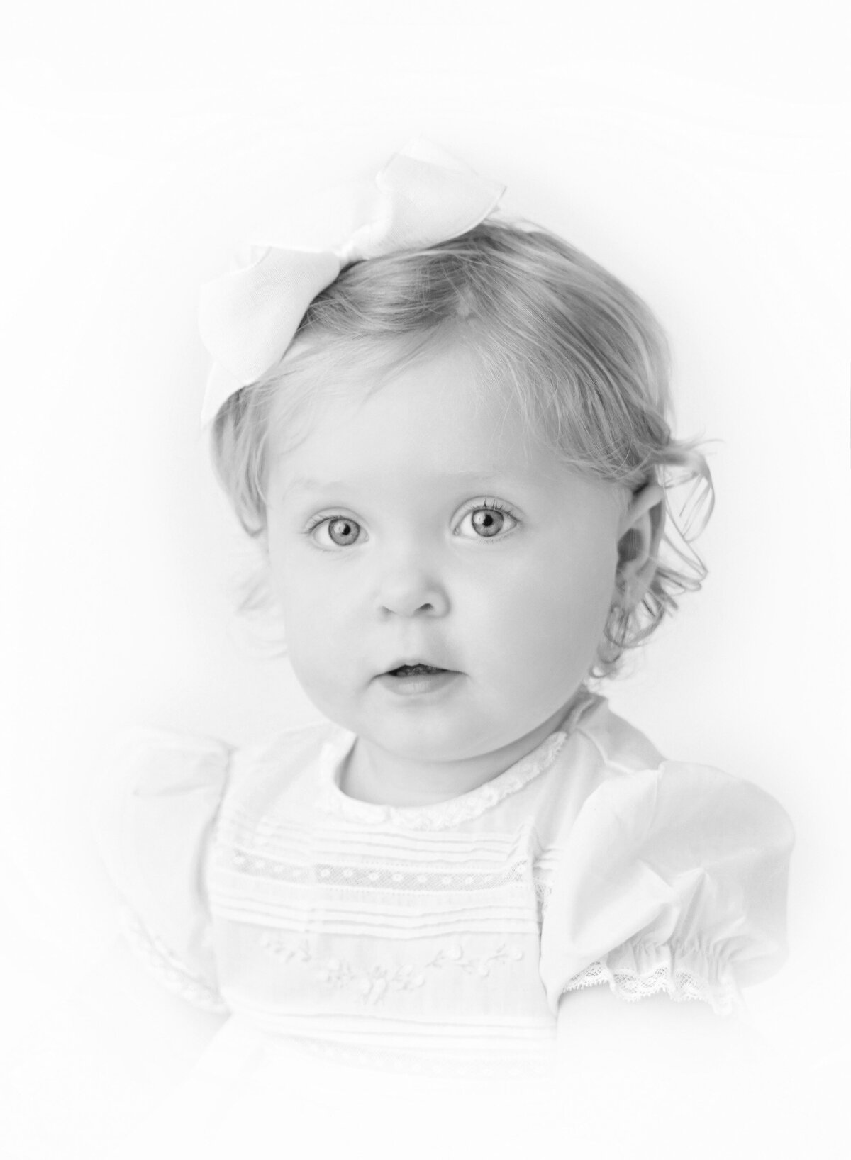 Black and white modern Heirloom portrait of a baby girl with soft curls and expressive eyes — timeless NYC Heirloom baby photography by Brooklyn photographer Rochel Konik.