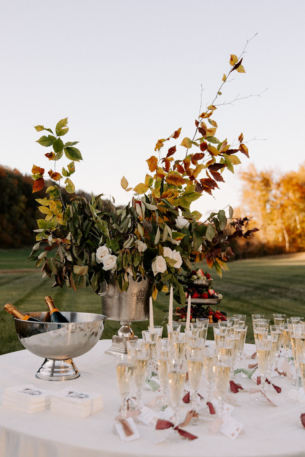 A champagne bucket with flowers on a table with champagne flutes at a Nashville wedding