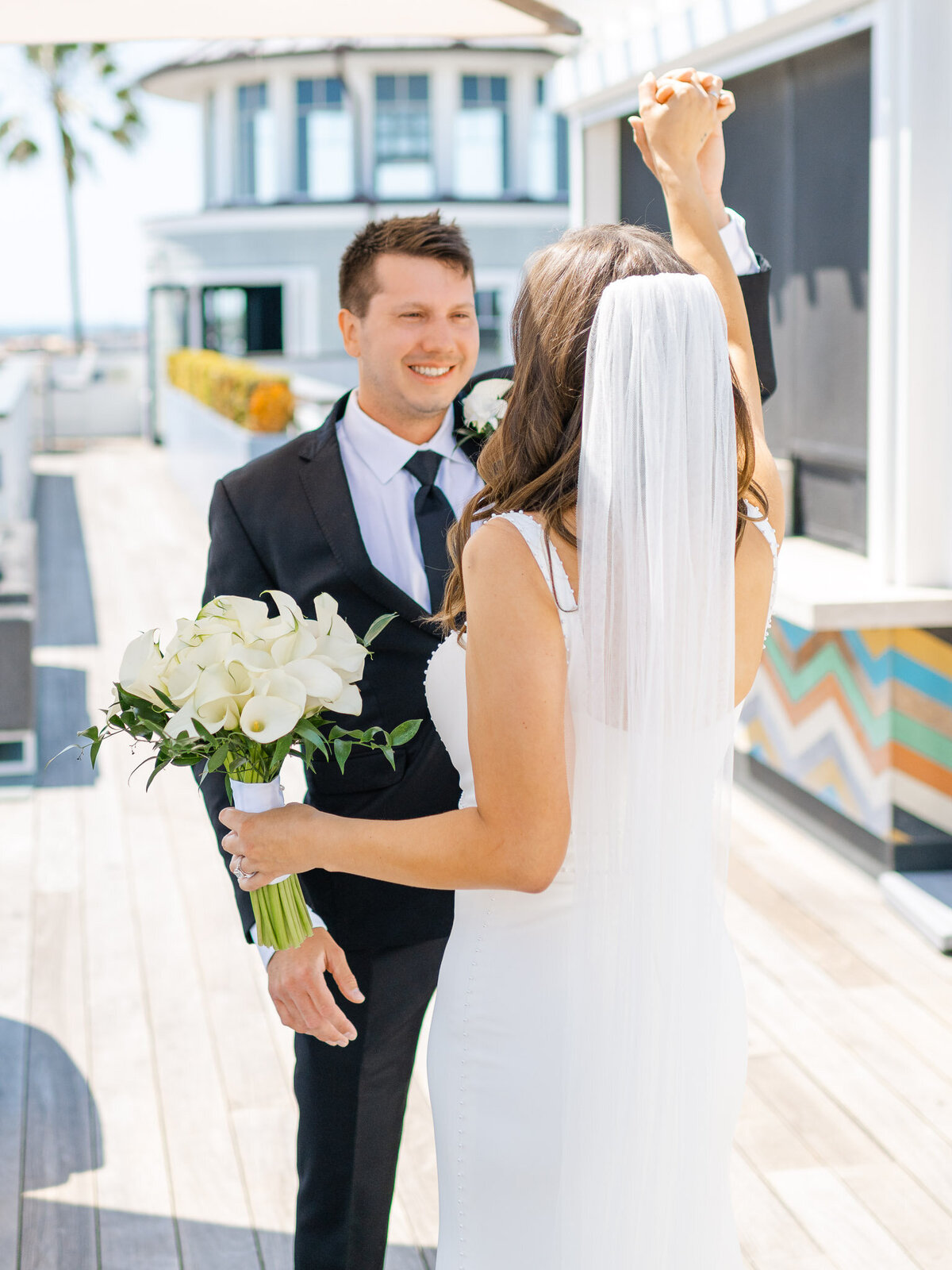 Groom smiles as he sees his bride for the first time during their first look at Lido House, Newport Beach.