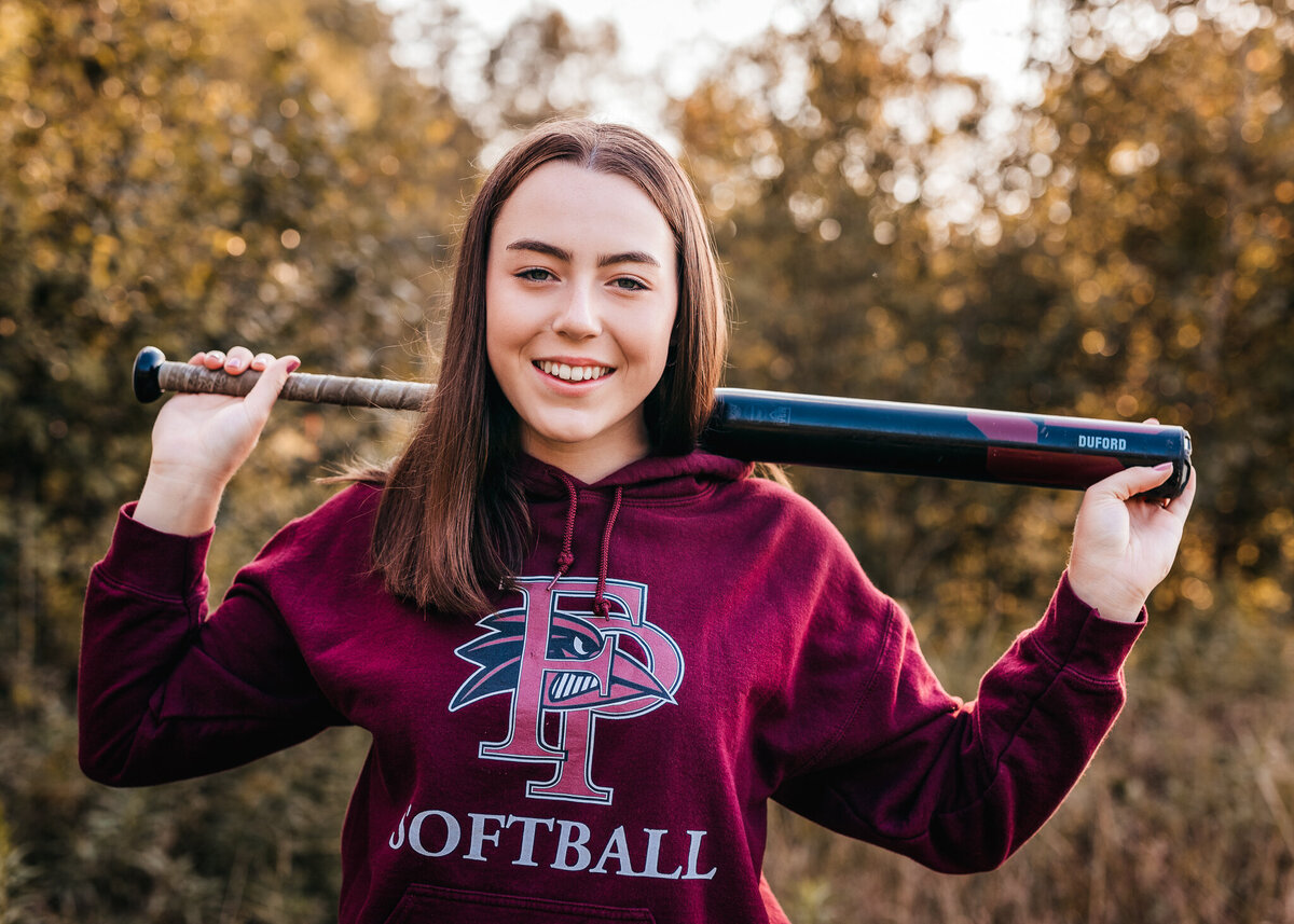 High School Softball player posing with baseball bat at audubon in NH by Lisa Smith Photography