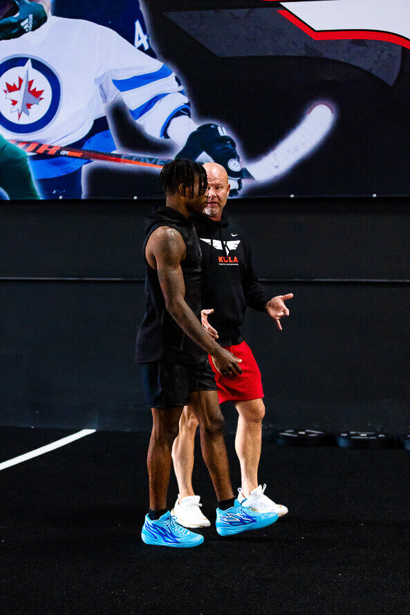 Brian Kula, of Kula Sports Performance, talks with football great Travis Hunter.