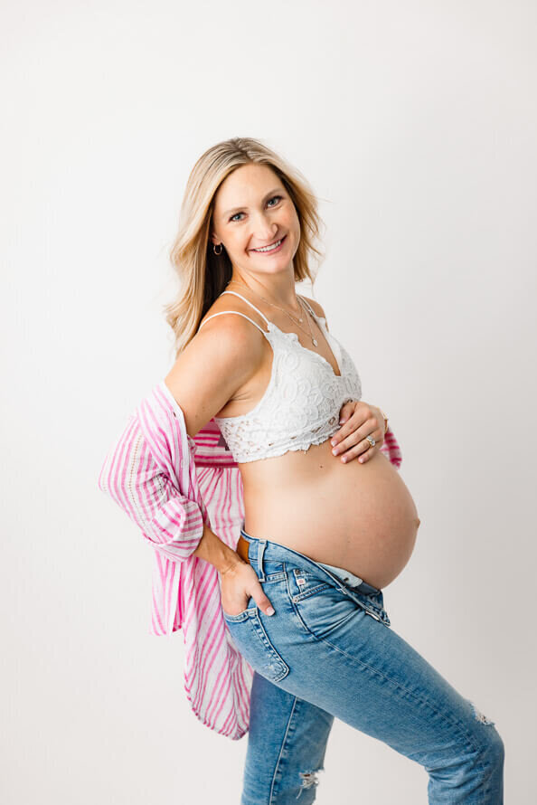 A side angle of a pregnant woman in the studio at Angela Marie Media.