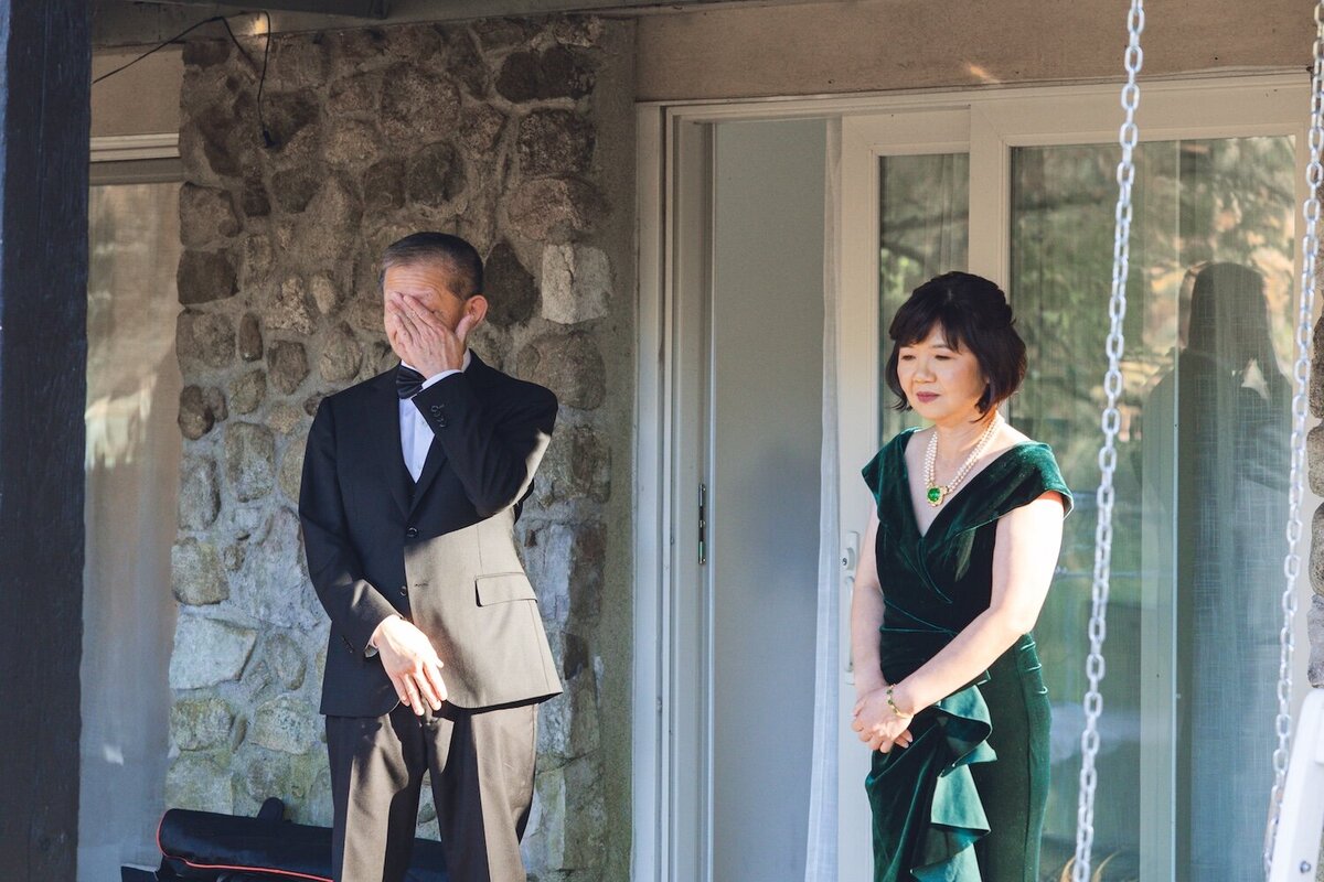 Father of the bride getting emotional while standing on the porch.