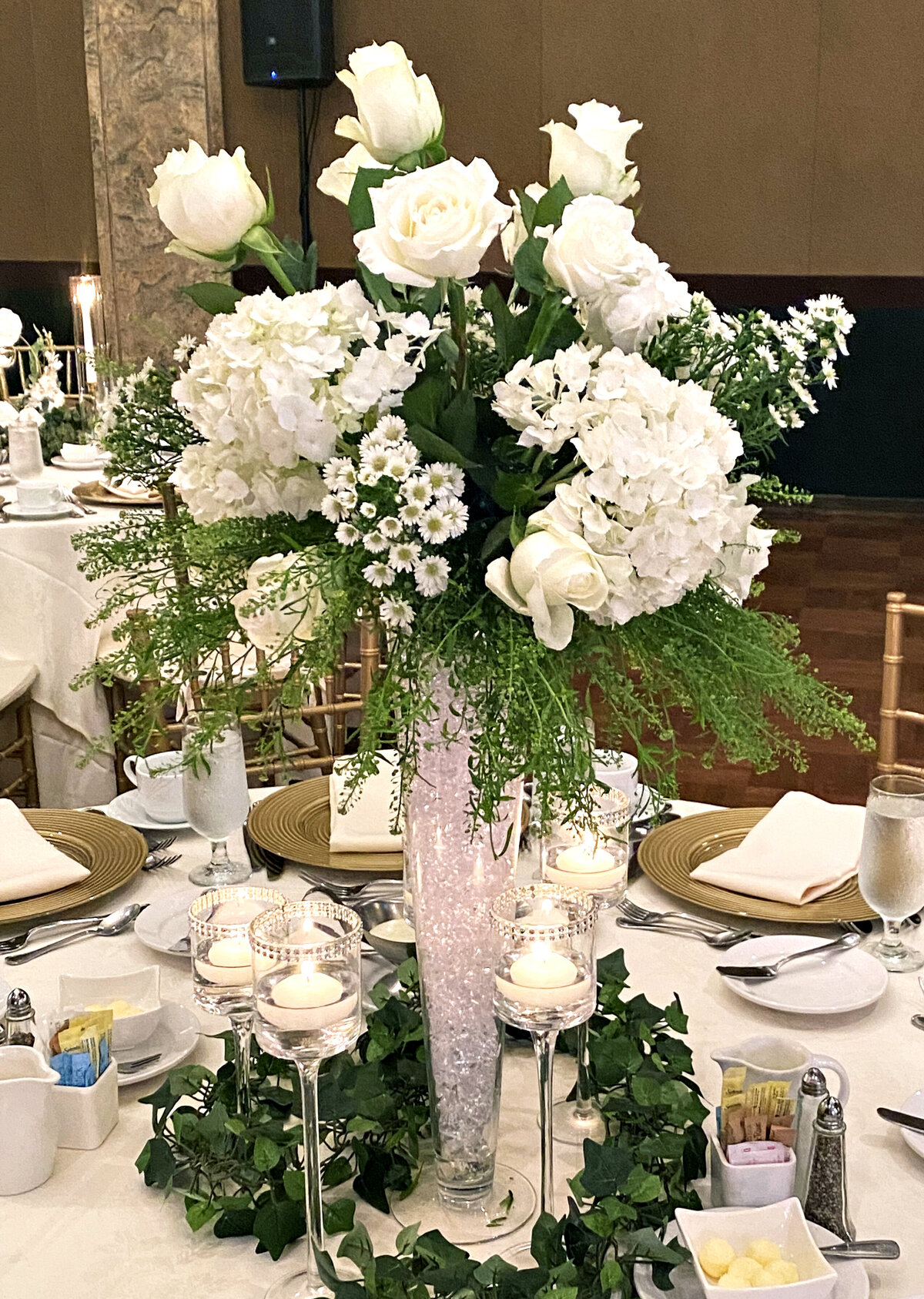 Tall floral centerpiece featuring lush white florals, adding elegance and grandeur to a wedding tablescape, designed by In Full Bloom Event Planning & Design